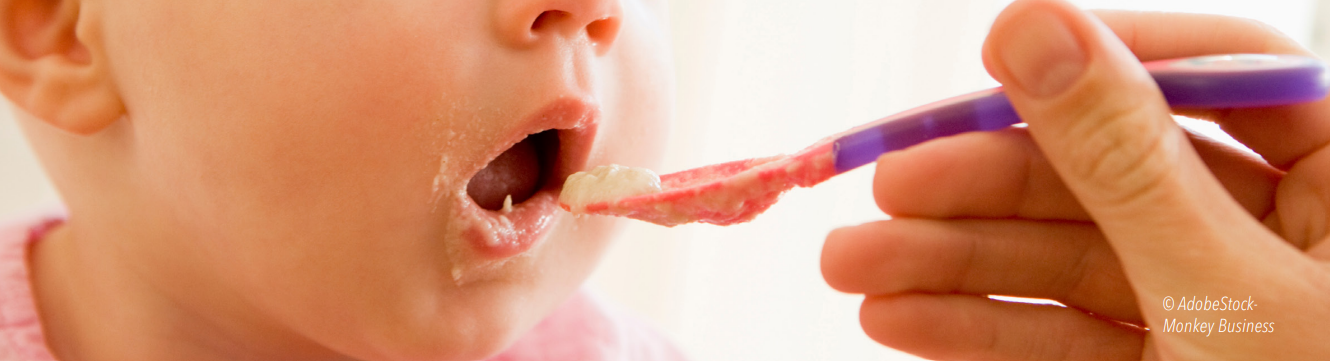 Bas du visage d'un bébé qui mange une cuillère de purée